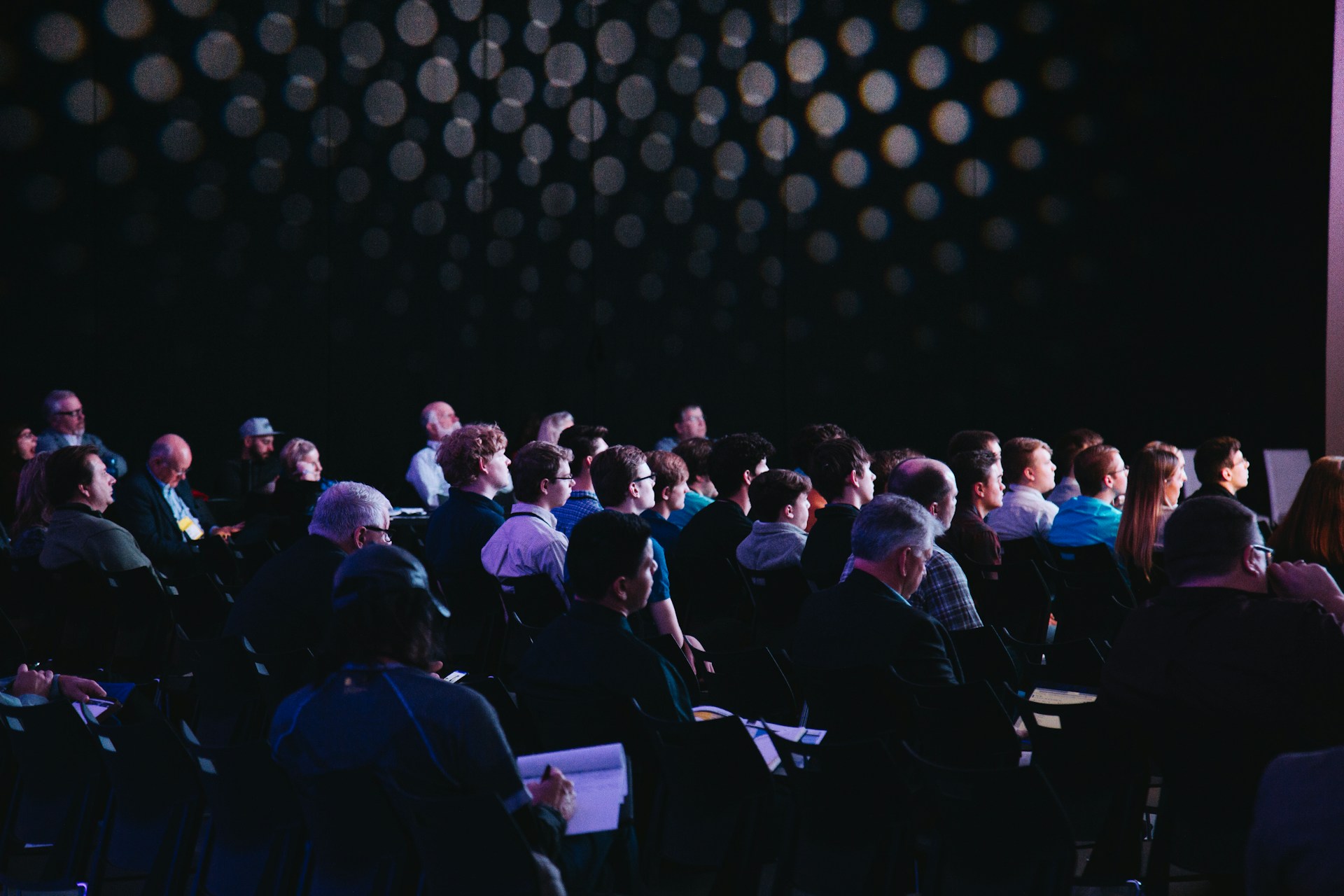 Speaker presenting at a technology conference with audience seated